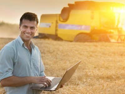 agricultural engineer with his laptop on wheat harvest