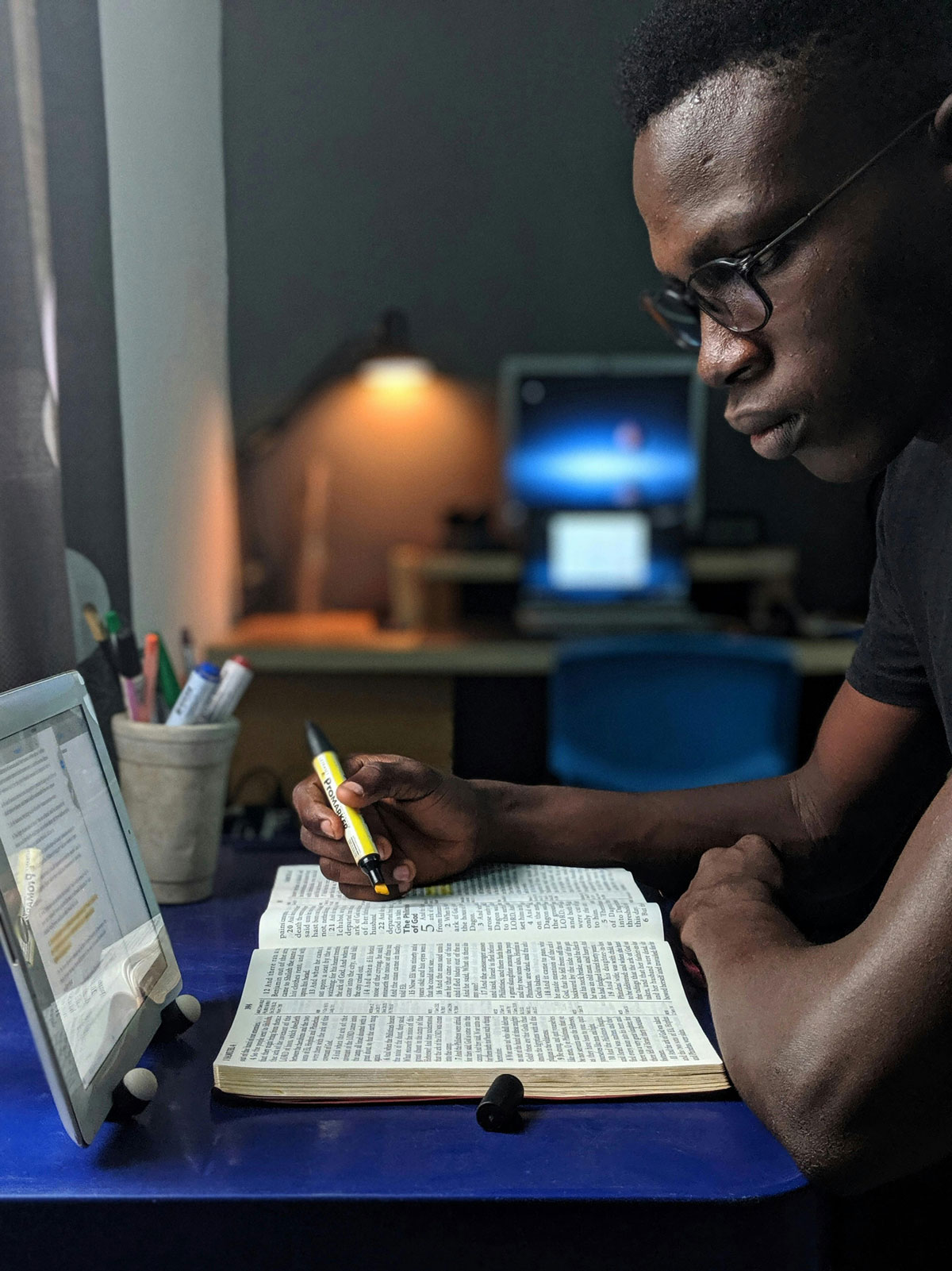 a man sitting at a table with a book and a pen