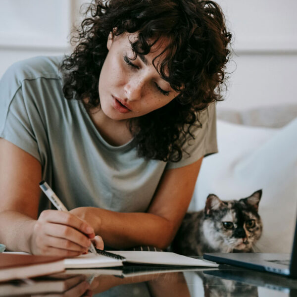 a woman writing on a notebook