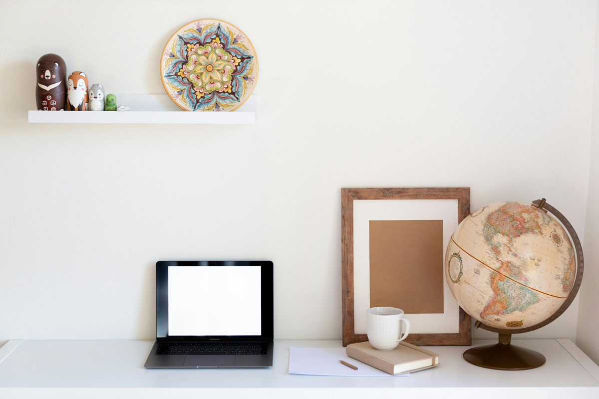 a laptop and globe on a shelf