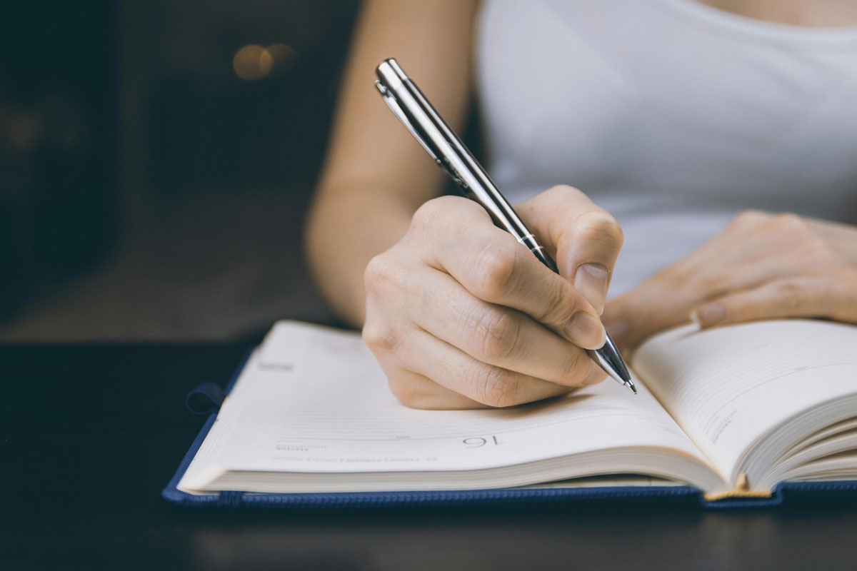 a person writing in a notebook