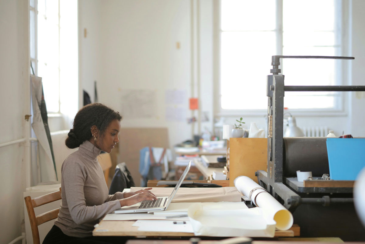 a woman sitting at a desk using a laptop