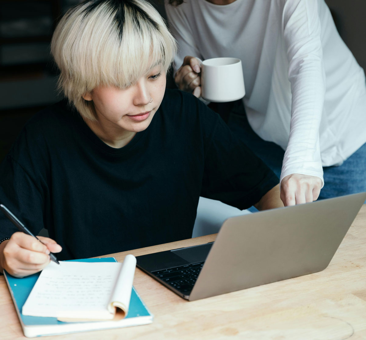 a woman holding a cup and a laptop