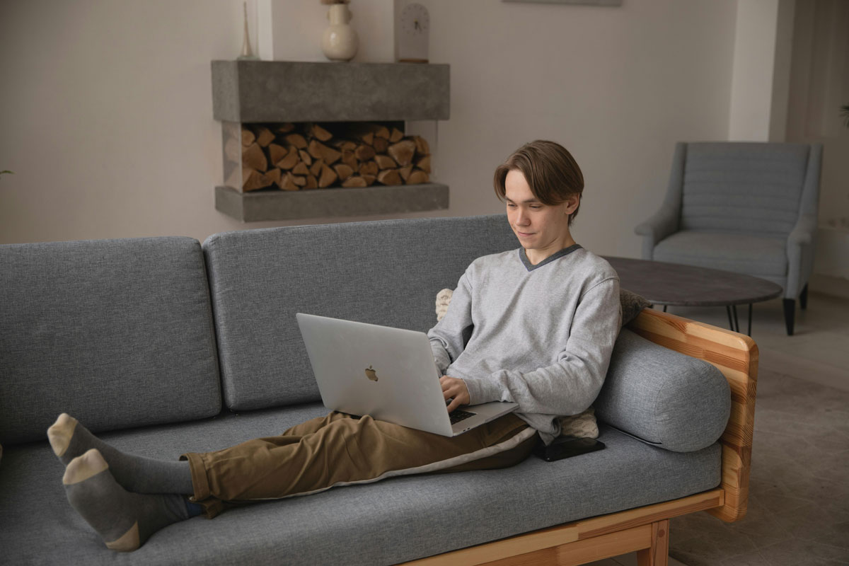 a man sitting on a couch using a laptop