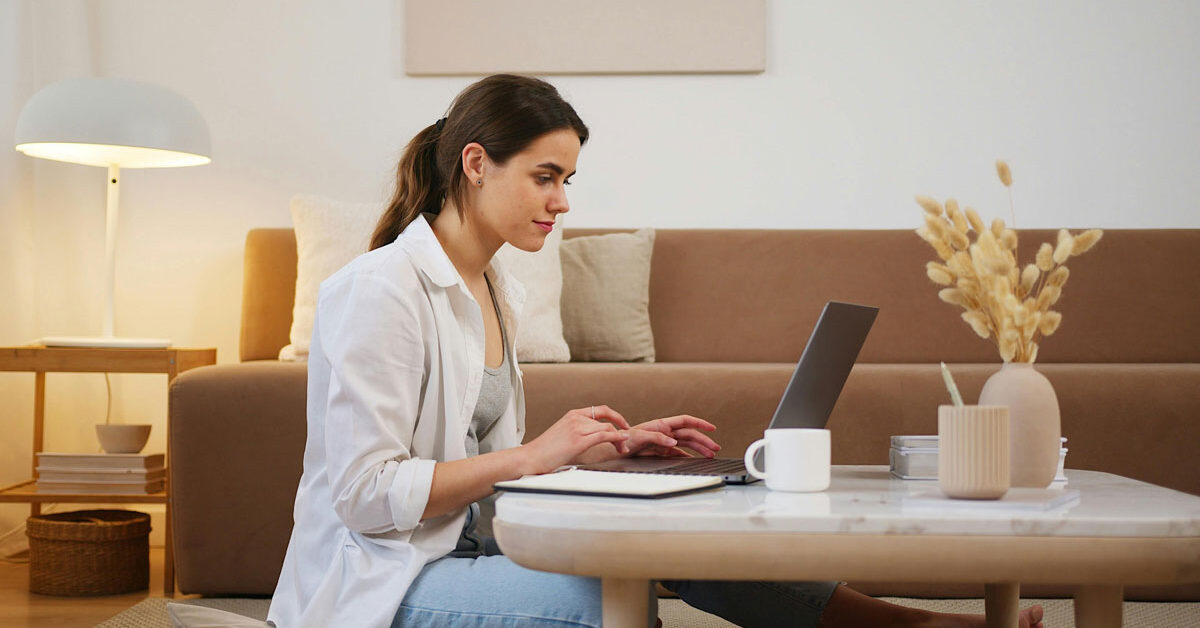 a woman sitting on a coffee table using a laptop