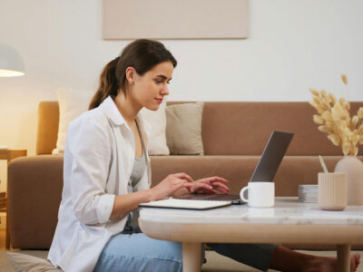 a woman sitting on a coffee table using a laptop
