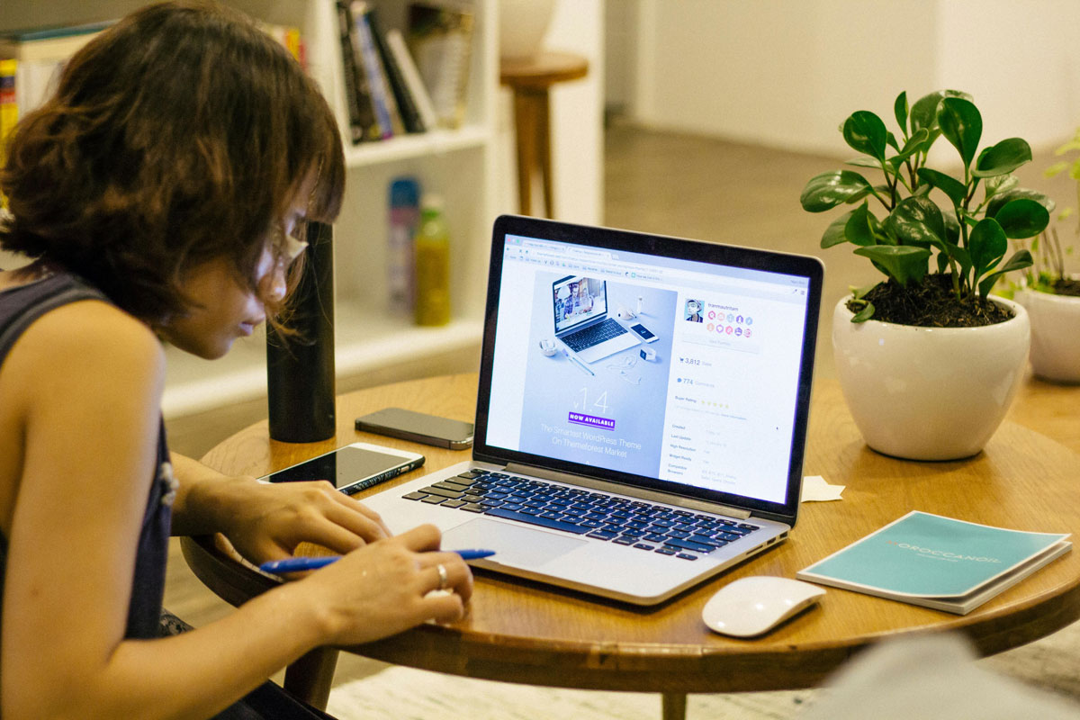 a woman sitting at a table with a laptop