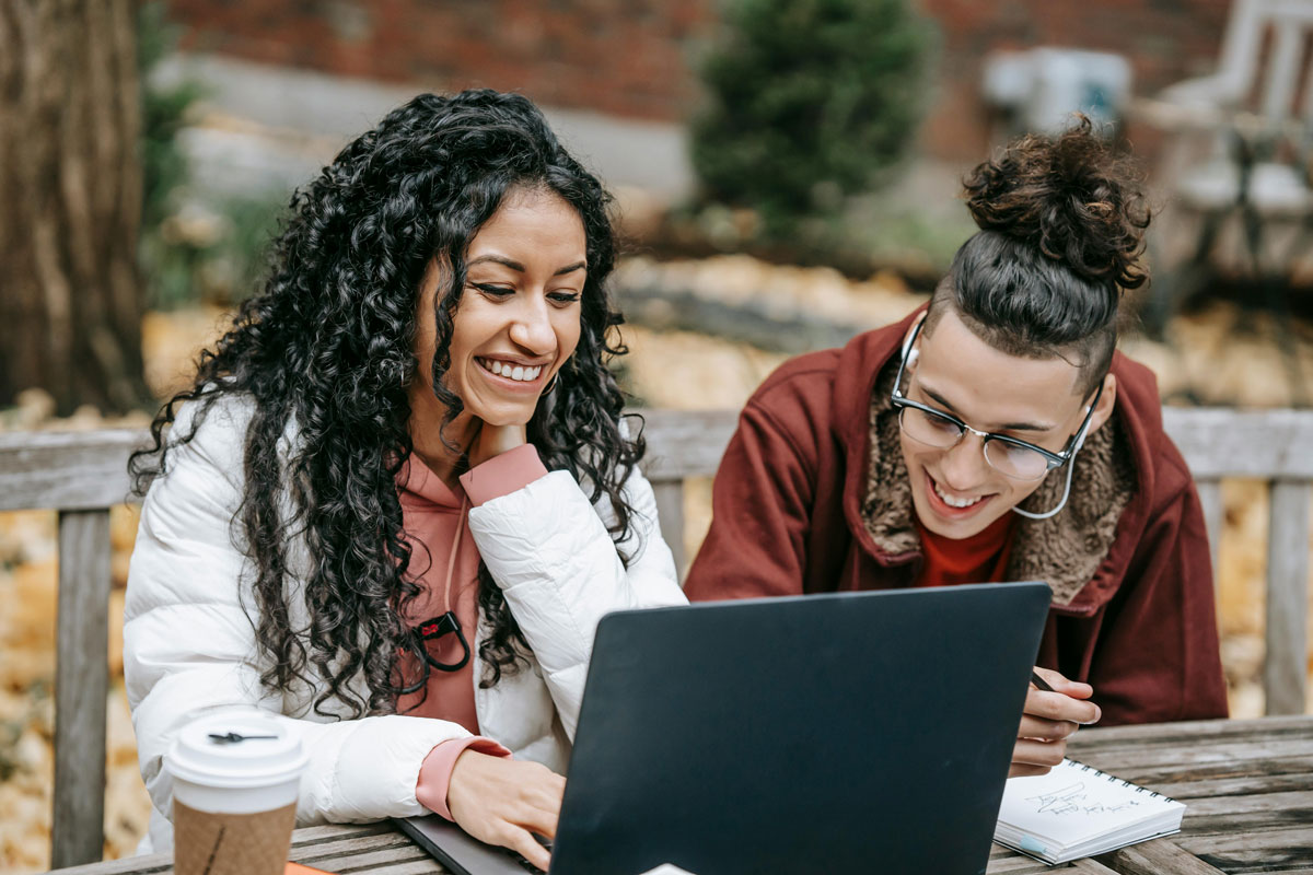 a man and woman looking at a laptop