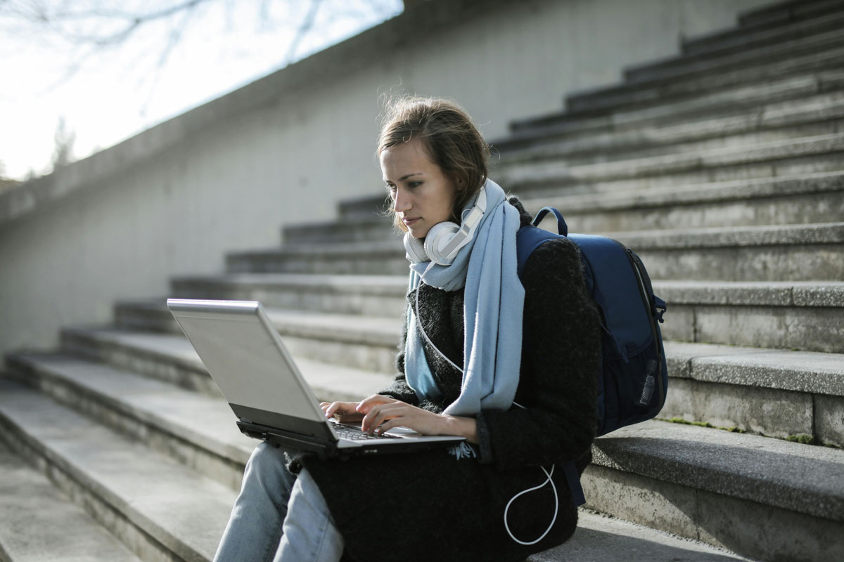 a woman sitting on stairs with a laptop