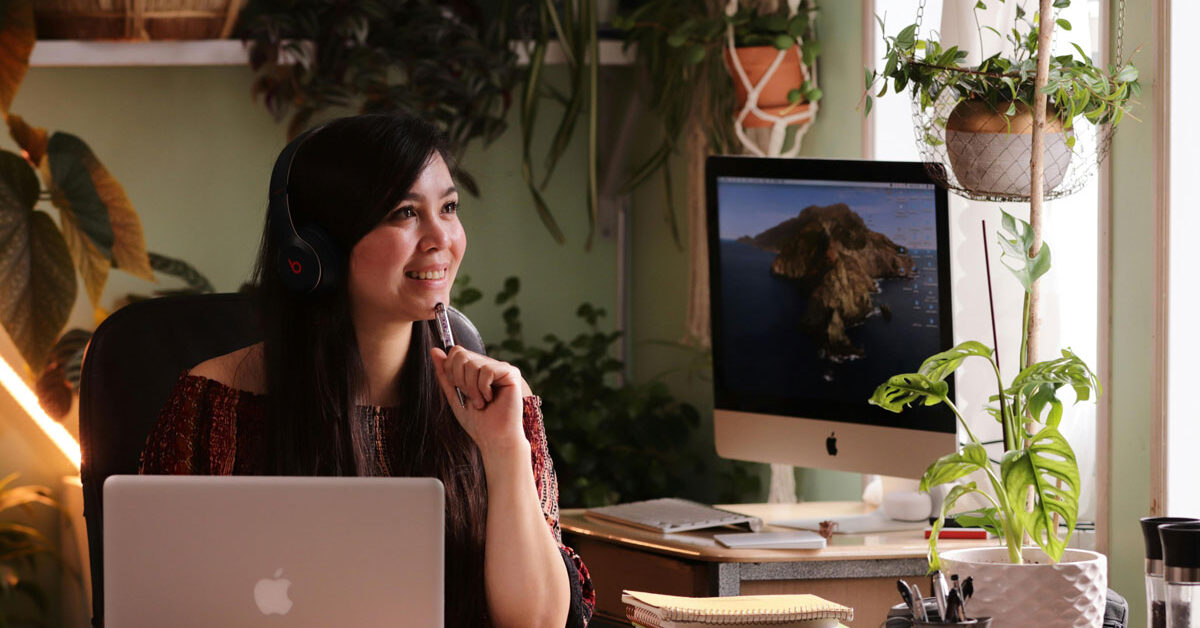 a woman sitting at a desk with headphones on
