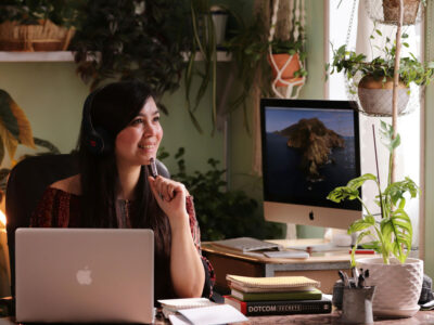 a woman sitting at a desk with headphones on