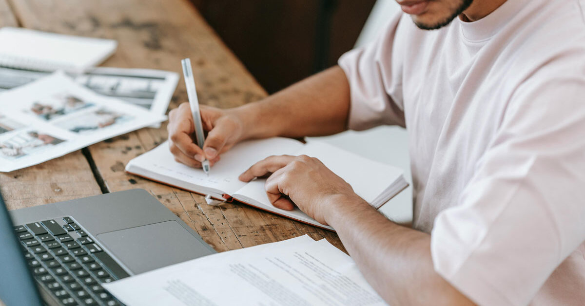 a man writing in a notebook