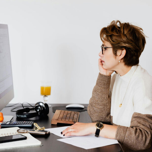 a woman sitting at a desk looking at a computer screen