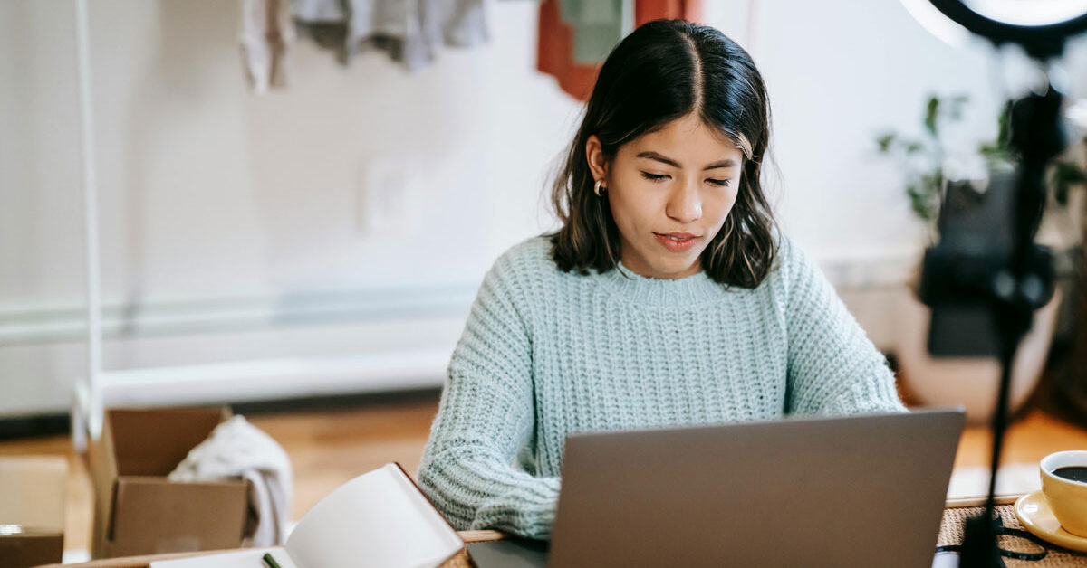 a woman sitting at a desk using a laptop