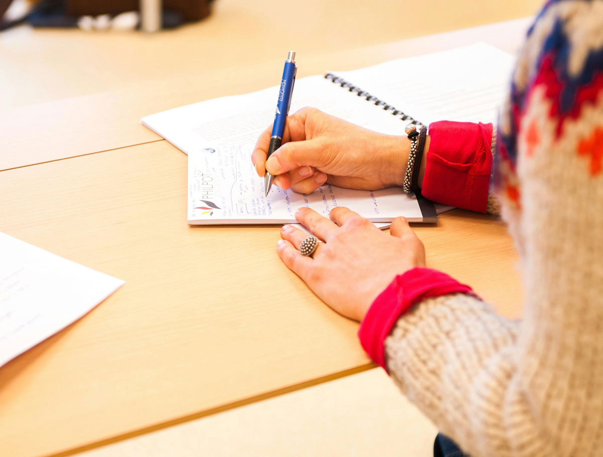 a person writing on a piece of paper