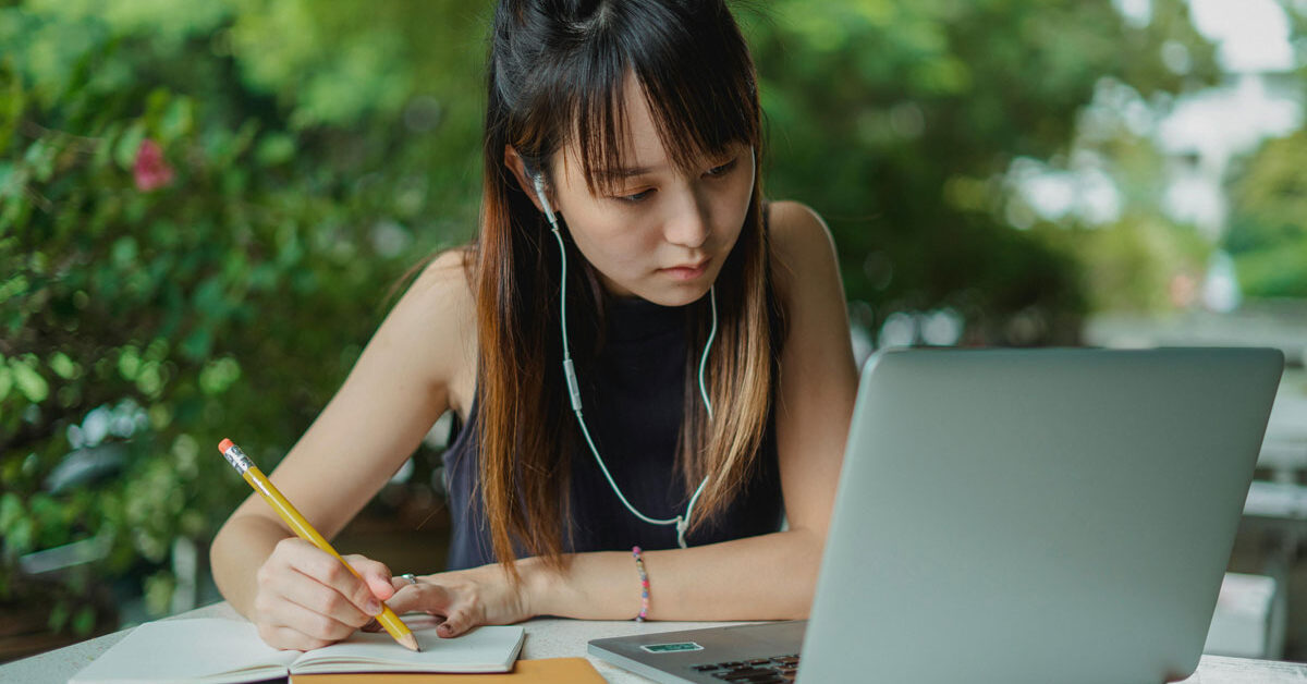 a woman writing on a notebook