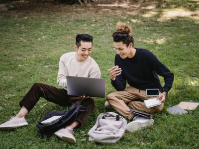 two men sitting on the grass